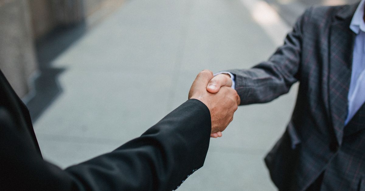 Two people shaking hands to close a deal