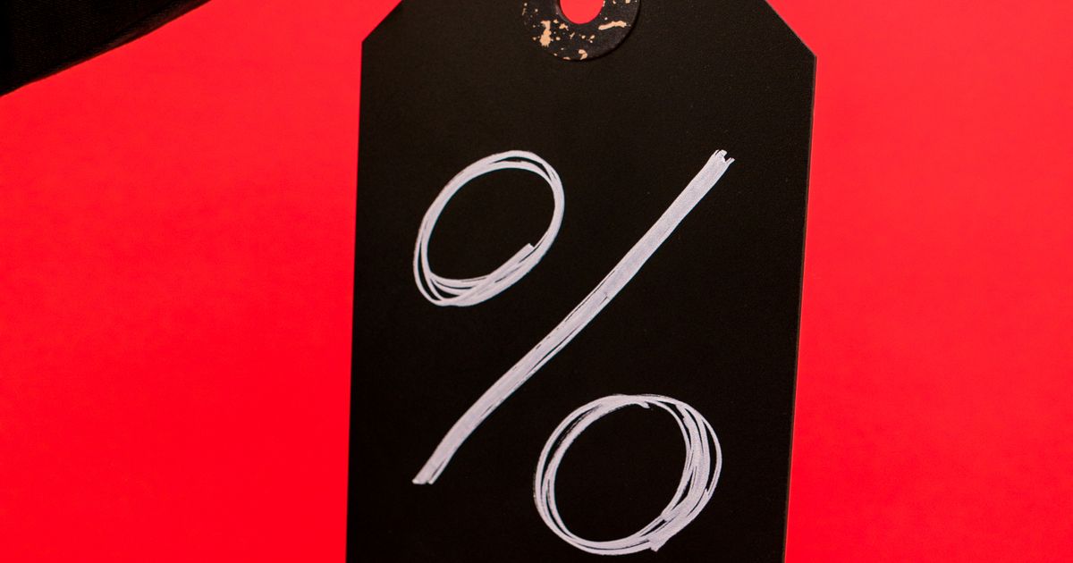 A black price tag with a percent sign on a red background