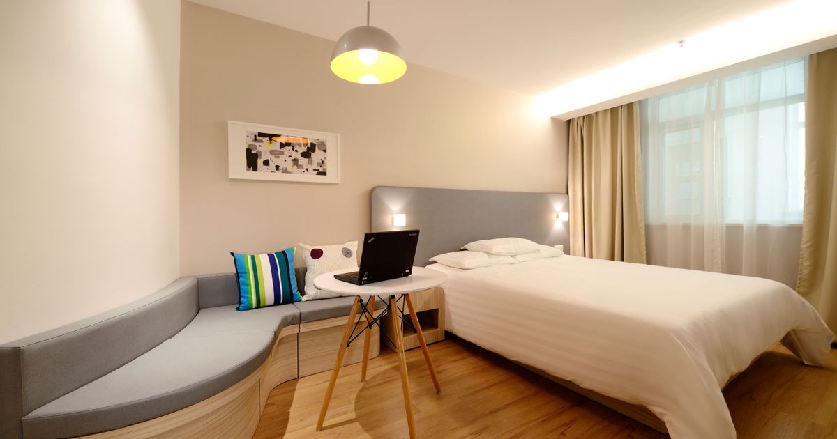 A hotel room with a laptop showing a booking website